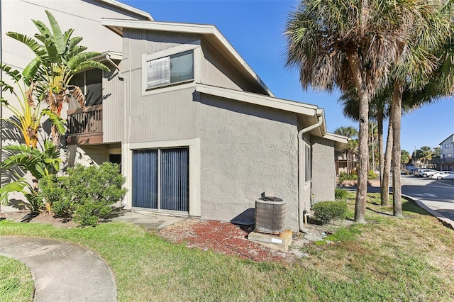 back of house featuring a yard and central AC unit