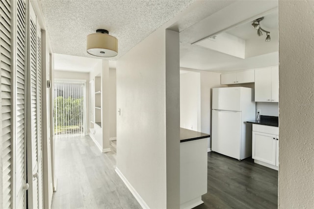 corridor featuring dark hardwood / wood-style flooring and a textured ceiling