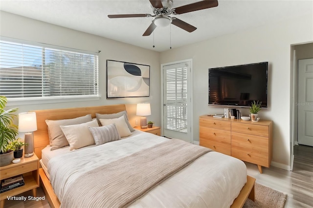 bedroom with hardwood / wood-style flooring, multiple windows, and ceiling fan