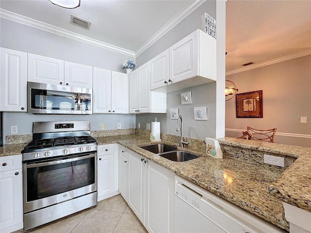 kitchen with white cabinets, stainless steel appliances, ornamental molding, and sink