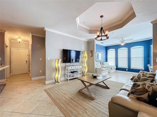 tiled living room featuring ceiling fan with notable chandelier, ornamental molding, and a textured ceiling