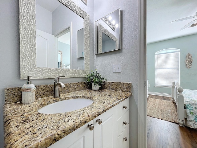 bathroom with ceiling fan, vanity, and hardwood / wood-style flooring