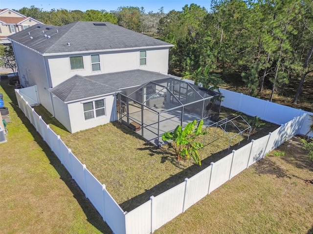 back of house featuring glass enclosure, a patio area, and a lawn