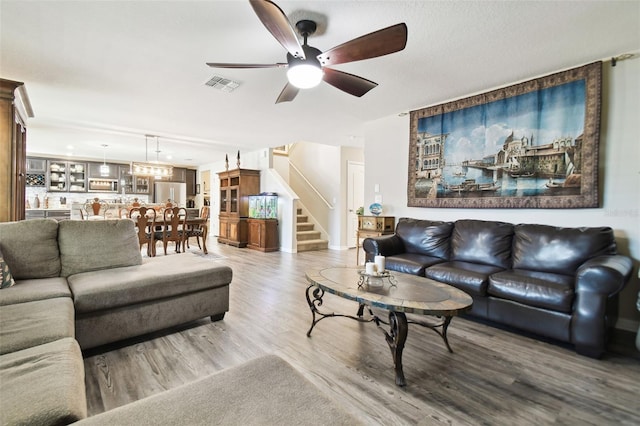 living room featuring ceiling fan and hardwood / wood-style floors