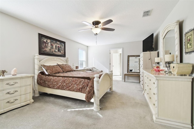 carpeted bedroom featuring ceiling fan and a textured ceiling