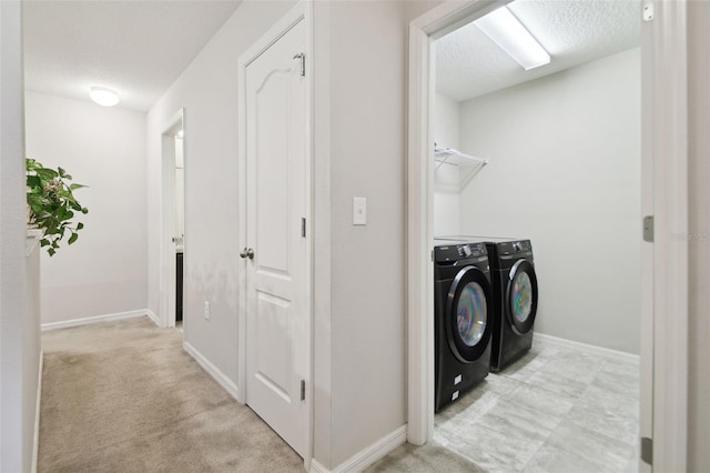 washroom with independent washer and dryer, a textured ceiling, and light colored carpet