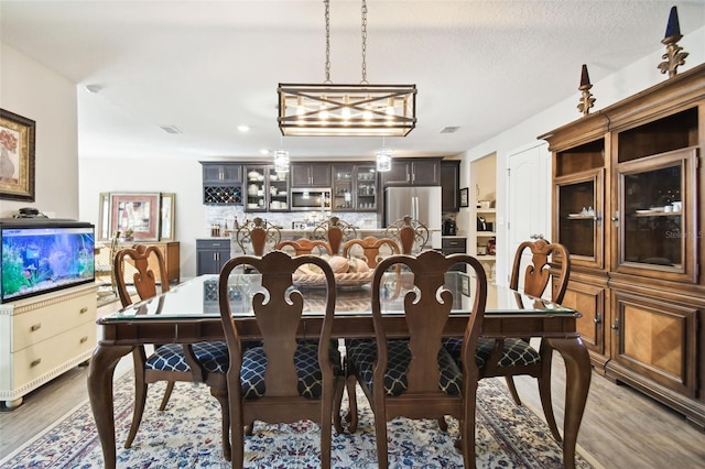 dining room with a textured ceiling and light wood-type flooring