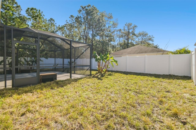 view of yard with glass enclosure and a patio area