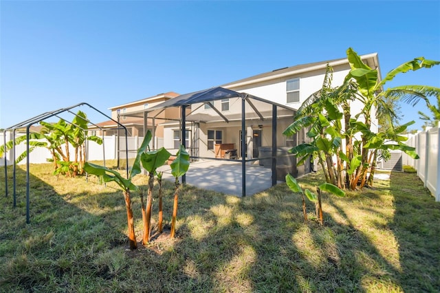 rear view of property featuring a patio, a yard, and glass enclosure