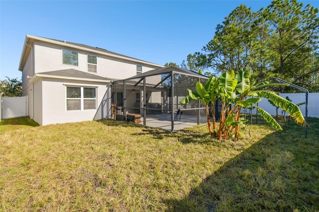 back of house with glass enclosure, a patio area, and a lawn