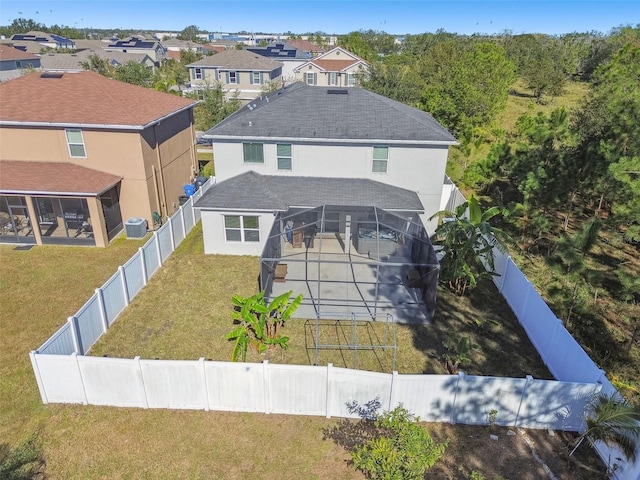 view of front of property with glass enclosure, a front lawn, central AC unit, a pool, and a patio area