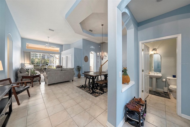 interior space featuring ceiling fan with notable chandelier