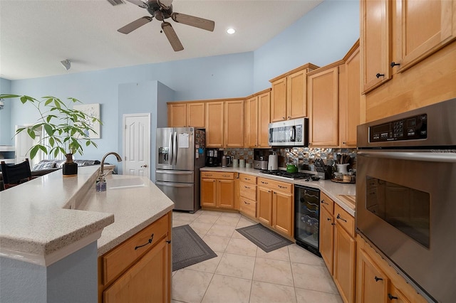 kitchen with a kitchen island with sink, sink, wine cooler, ceiling fan, and stainless steel appliances