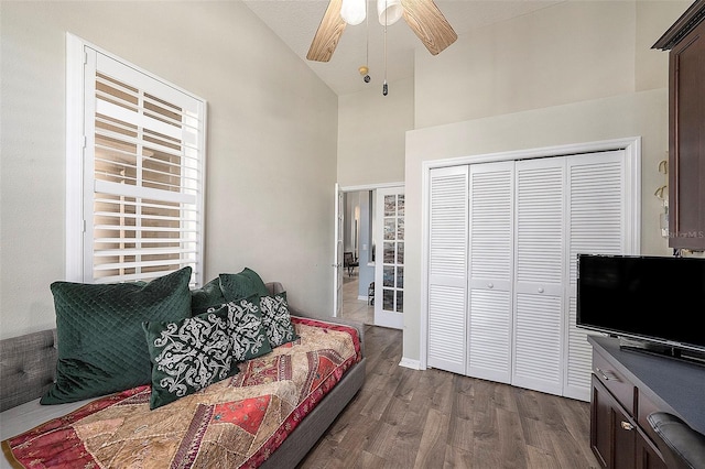 living room featuring a textured ceiling, hardwood / wood-style flooring, high vaulted ceiling, and ceiling fan