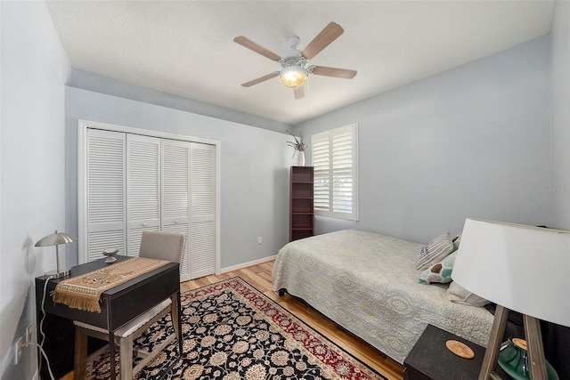 bedroom featuring ceiling fan, a closet, and light wood-type flooring