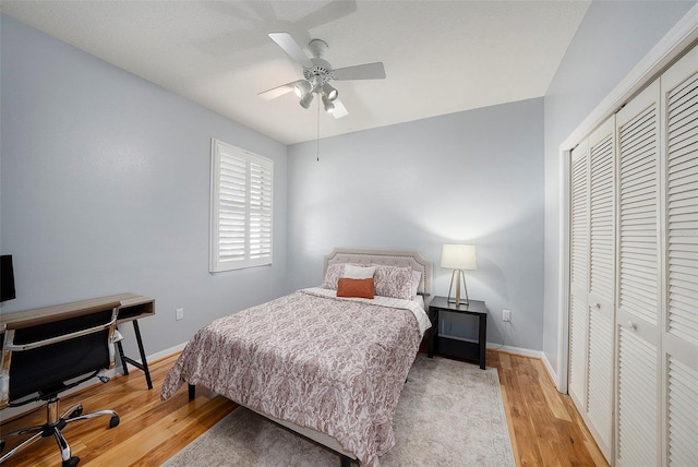 bedroom with ceiling fan, light wood-type flooring, and a closet