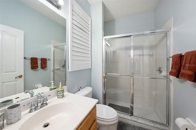 bathroom with toilet, an enclosed shower, and vanity