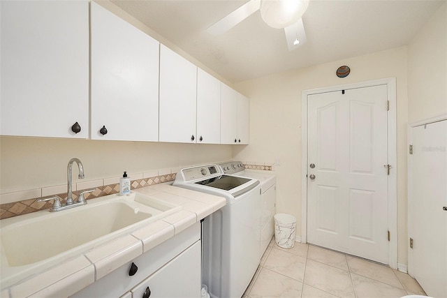 laundry area featuring washing machine and clothes dryer, ceiling fan, sink, and cabinets