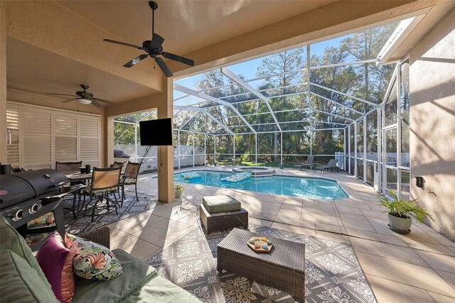 view of pool featuring a patio area, ceiling fan, glass enclosure, and an in ground hot tub