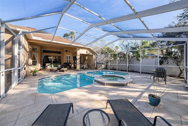 view of swimming pool featuring glass enclosure, an in ground hot tub, ceiling fan, and a patio