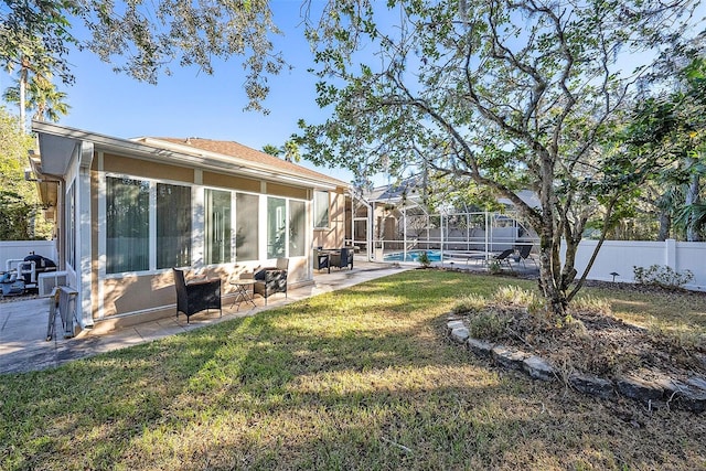 view of yard with a lanai, a sunroom, a patio area, and a fenced in pool