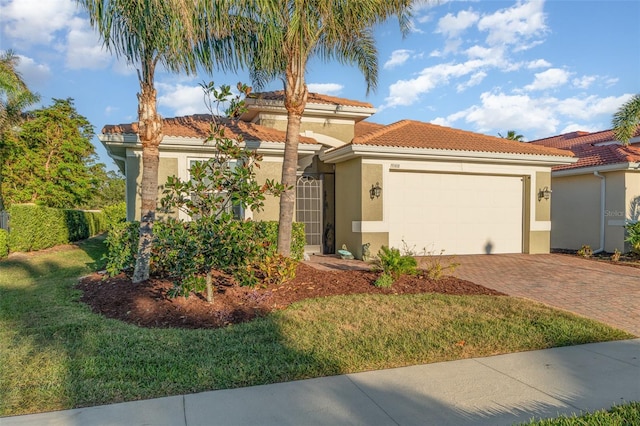 mediterranean / spanish-style home with a garage and a front lawn