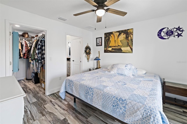 bedroom with a walk in closet, ceiling fan, a closet, and wood-type flooring