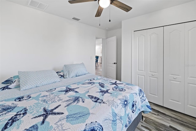 bedroom with ceiling fan, a closet, and hardwood / wood-style flooring