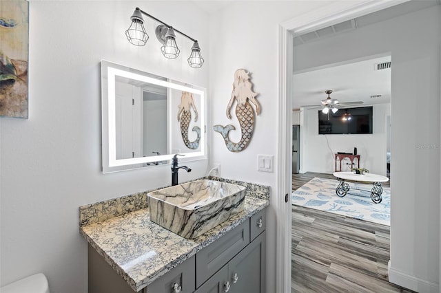 bathroom with ceiling fan, vanity, and wood-type flooring