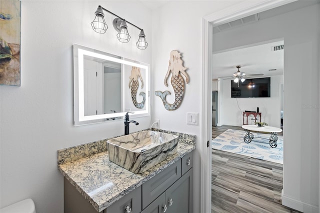 3270 Hibiscus Dr, Hernando Beach, FL 34607 - bathroom with vanity, wood finished floors, toilet, and a ceiling fan