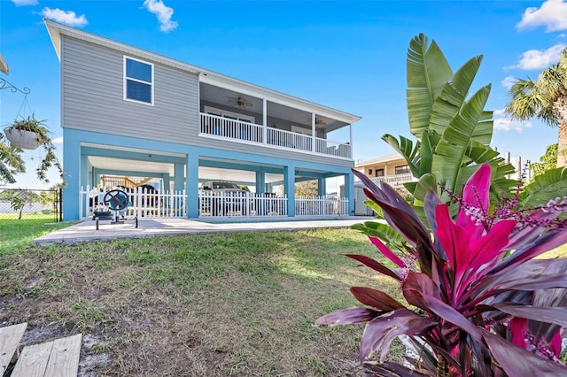 rear view of property with a lawn, a patio area, and ceiling fan