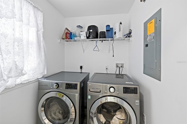 clothes washing area featuring electric panel and washing machine and clothes dryer