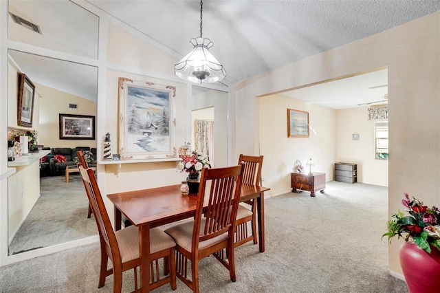 dining room featuring light carpet, a textured ceiling, a chandelier, and lofted ceiling