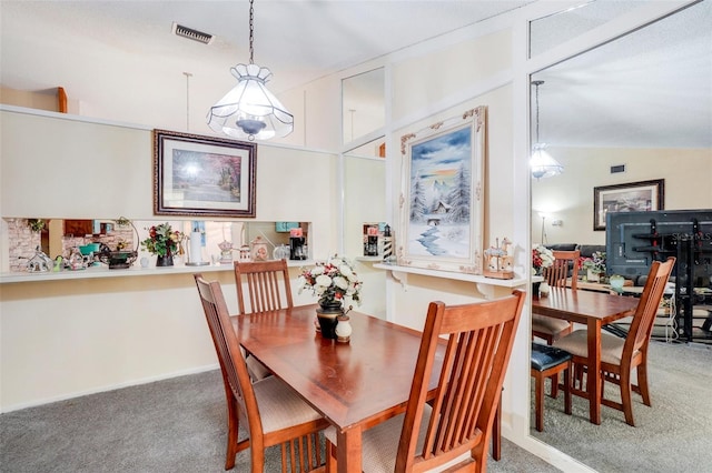 carpeted dining room with vaulted ceiling