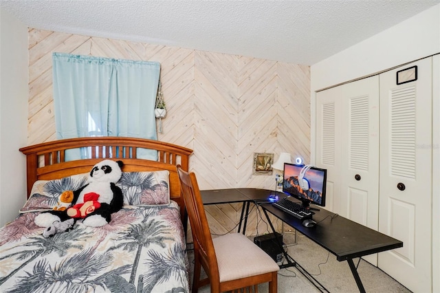 bedroom featuring a textured ceiling, wooden walls, and a closet