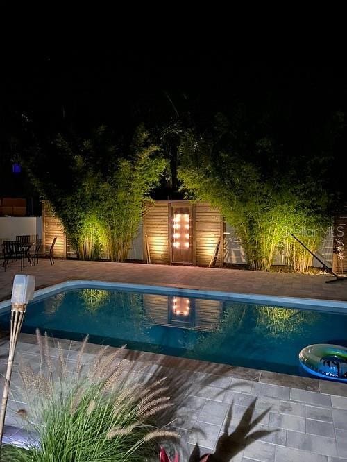 pool at twilight featuring a patio