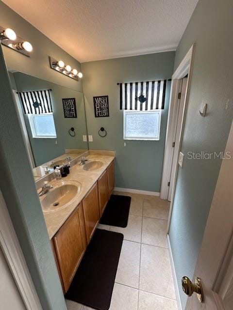 bathroom featuring tile patterned floors, vanity, and a textured ceiling