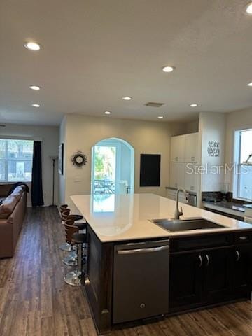 kitchen featuring a breakfast bar, sink, a center island with sink, dishwasher, and dark hardwood / wood-style floors