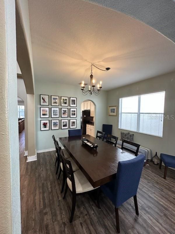 dining room with a chandelier, a textured ceiling, and dark hardwood / wood-style flooring