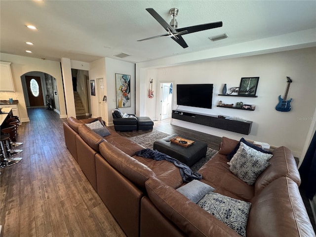 living room with ceiling fan and dark wood-type flooring