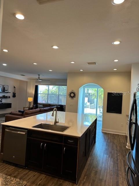 kitchen featuring ceiling fan, sink, dark hardwood / wood-style flooring, stainless steel dishwasher, and black refrigerator