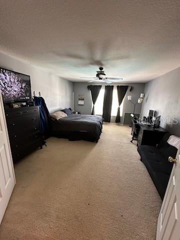 carpeted bedroom with a textured ceiling and ceiling fan