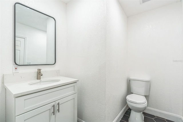 bathroom featuring tile patterned floors, vanity, and toilet