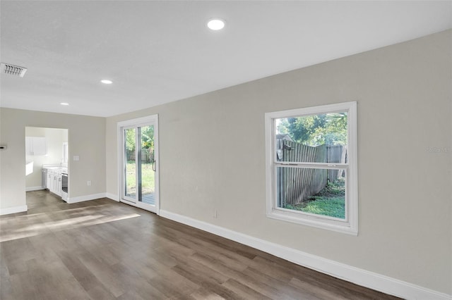 unfurnished living room with dark hardwood / wood-style floors and a wealth of natural light