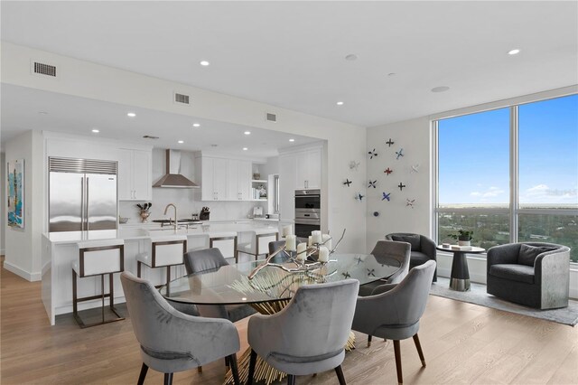 dining space with sink and light hardwood / wood-style floors