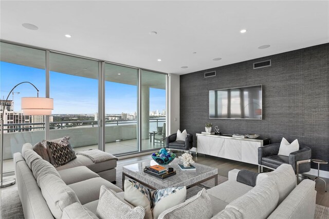 living room featuring wood-type flooring and a wall of windows