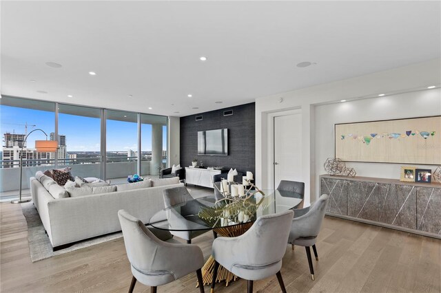 dining area with expansive windows and light hardwood / wood-style floors