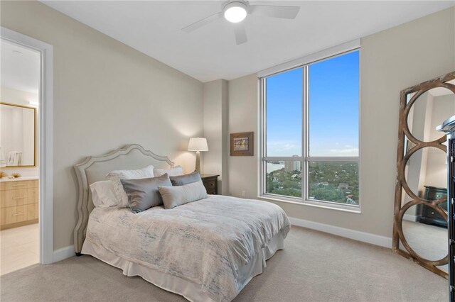 carpeted bedroom featuring ceiling fan and ensuite bath