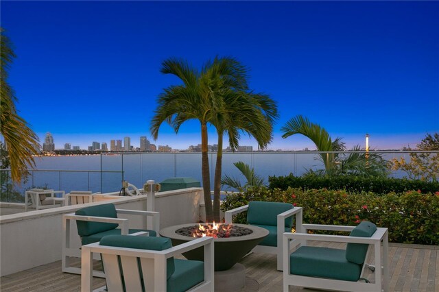 patio terrace at dusk with a water view and a fire pit