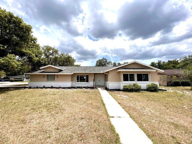 ranch-style home featuring a front lawn